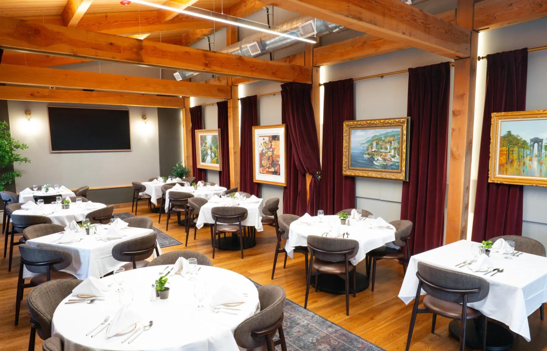 Joey's private dining room set with white tablecloths under framed paintings