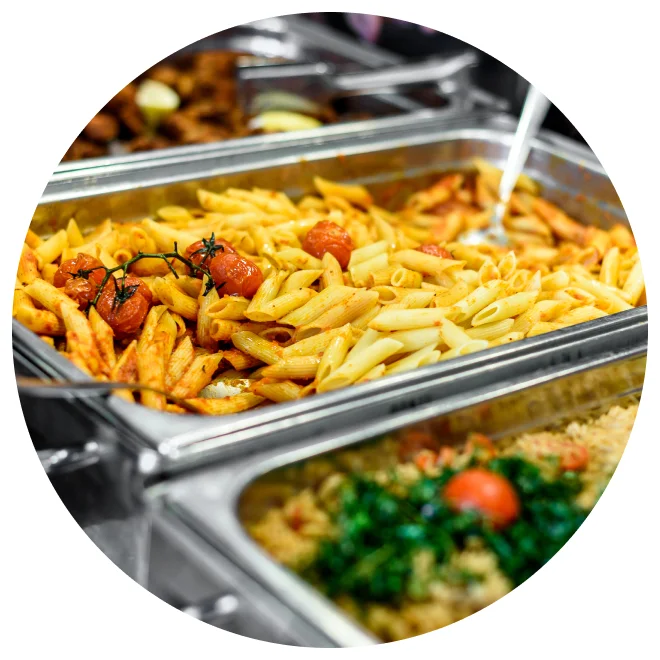 Catering trays of penne pasta and greens
