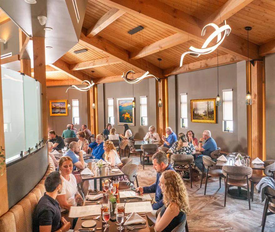 Guests dining under the wood-beamed ceiling of Joey's dining room