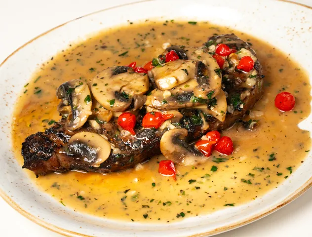 Mussels and greens in a bowl of golden broth