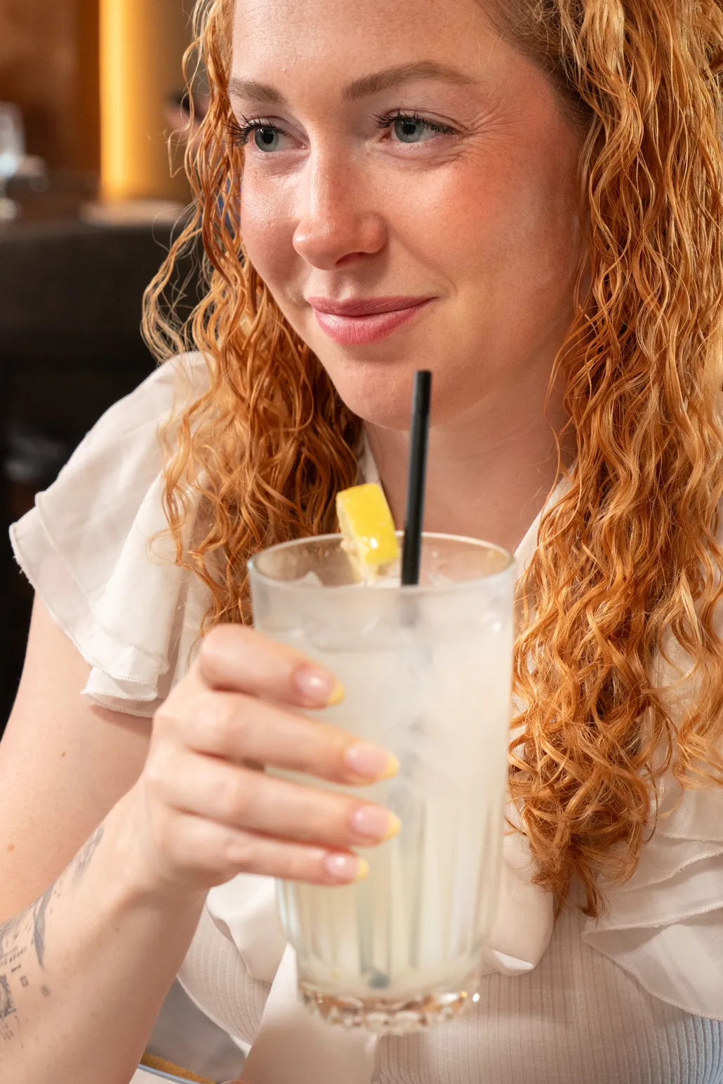 A guest at Joey's smiling over a glass of lemonade
